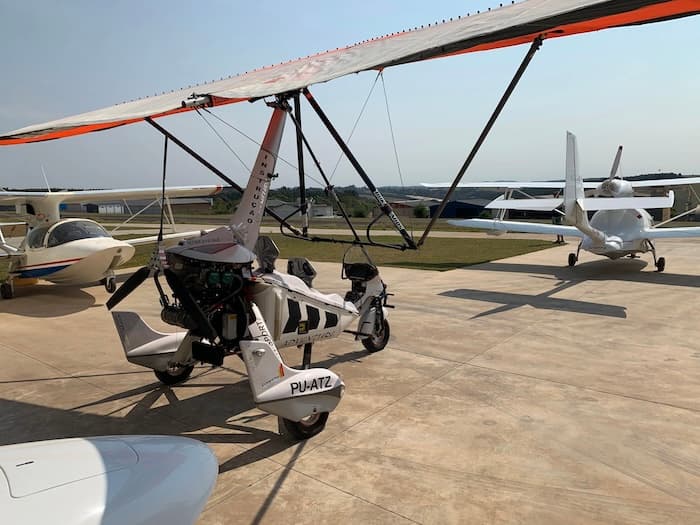 Trike estacionado em foco com aviões ao fundo